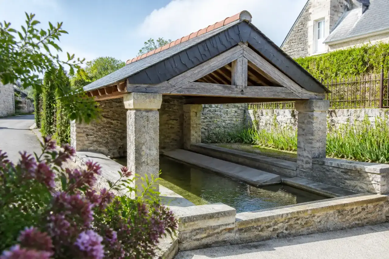 Lavoir breton en pierre restauré dans un paysage de bocage